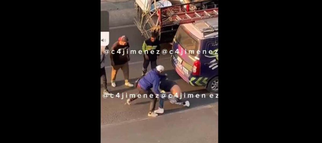 Un vehículo pasó muy cerca cuando los sujetos resolvían sus diferencias a golpes. Foto: Captura de Video